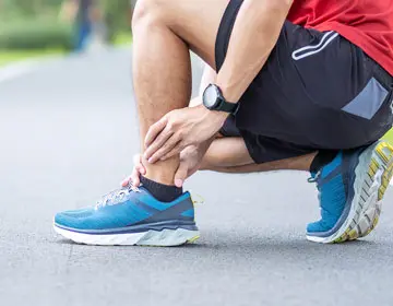 Injured runner suffering from ankle or achilles sprain